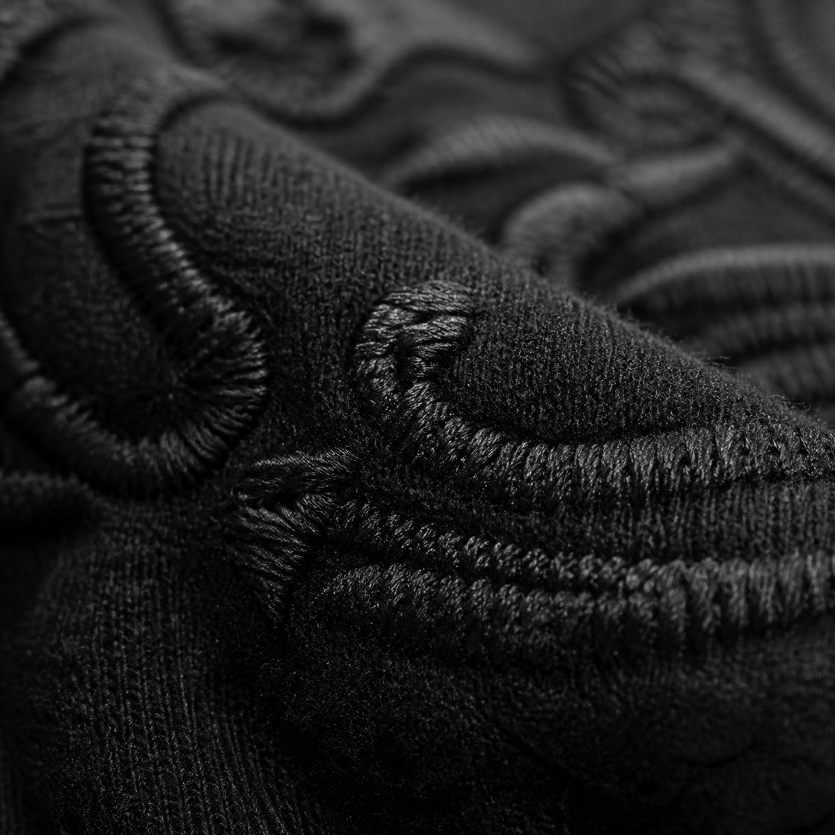 Macro detail of heavyweight fabric and tonal embroidery